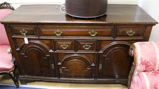 A George III style oak dresser base, fitted five drawers and three arcaded panelled cupboards, W.153cm